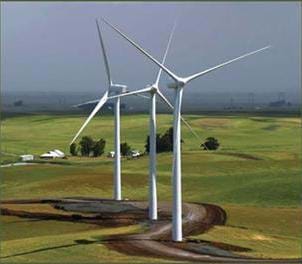 A photograph of wind turbines, also known as a wind farm. Blowing wind causes a turbine to rotate, turning an electric motor which makes electricity.
