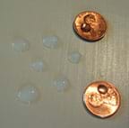  Photo of droplets of water on pennies and on a waxed tabletop.