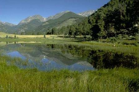 A photograph of Sheep Lakes, in Rocky Mountain National Park in Colorado. The image illustrates glacier erosion through the shown U-shaped valley of mountains with a lake in front of the valley.