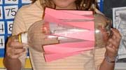  Photo of a two-liter bottle with paper paddles taped around the middle section.