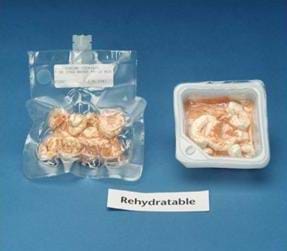 An image of two different packages of rehydratable shrimp cocktail. The package on the left is clear and vacuum sealed, and has a short tube placed in the side for adding water. The package on the right is a translucent plastic square box, with the lid removed. A sign below the packages reads: "Rehydratable." 