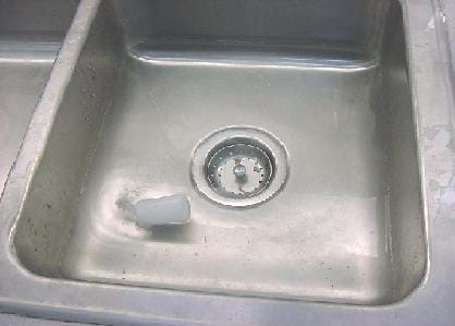 A photograph showing a rocket-powered boat, or aqua thruster, in a sink of water. The rocket boat is made from a film canister and contains an antacid tablet and water.