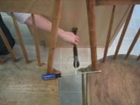 The hammer and rod have been connected and are resting across two chairs.