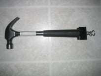 This is a picture of a hammer with a binder clip attached to it rather than string.