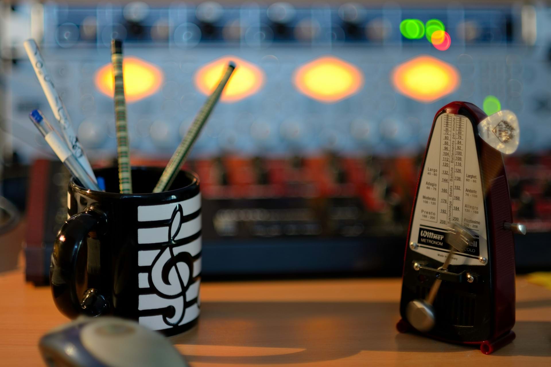 A metronome with a cup with a music note with pens