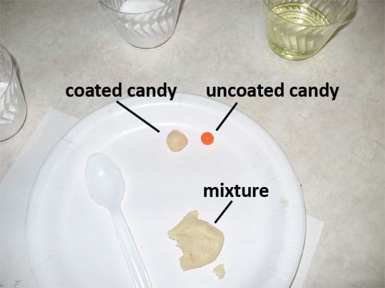 A photo shows a piece of candy covered with the beige mixture (coated) next to a piece of red candy (uncoated) on a paper plate.