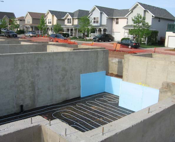 Photo shows a series of unfinished concrete walls that form basements for a new neighborhood.
