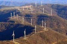 Photograph of 18 wind turbines located on a mountain ridge.