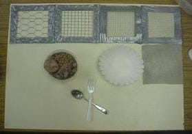 A photograph showing the activity "filters." From left to right are different-sized screening with large holes to small holes. Also shown is poultry netting, a coffee filter, a container of pebbles and a fork and spoon.