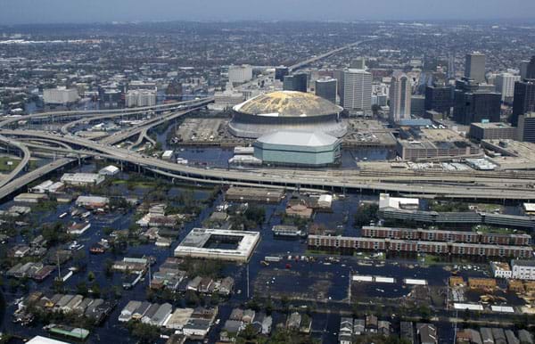 An aerial photograph shows flooded streets, buildings, highways, skyscrapers and superdome.