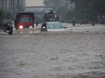 Cars and people amidst the flooded streets of Jakarta in Indonesia on January 17, 2013.