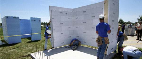 The image shows a group of engineers assembling a concrete foundation for a building.
