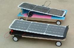 Photo shows two solar cars built by middle school students from Rogers Herr Middle School in Durham, NC, while participating in the Duke University Techtronics Program. They look like solar panels on skateboards.