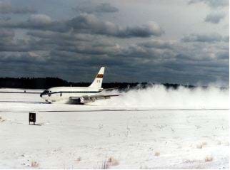 A photograph shows an airplane landing on a snowy runway.