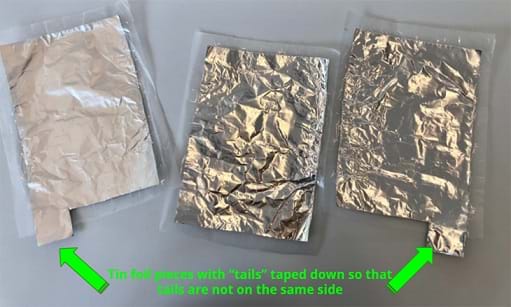A photograph shows 3 pieces of wax paper with 3 pieces of tin foil taped to them. There are arrows to show that the tin foil tails are taped down so that the tails are not on the same side. 
