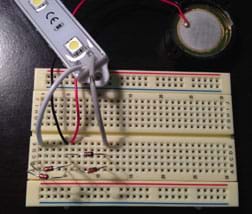 The same breadboard as Figure 3, now with an LED light bar connected via two wires.