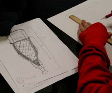 Photo shows a student sketch of a crutch with measurements and an idea for a net-covered frame as a carrying device.