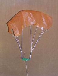 Photo shows a parachute made with a paper canopy, six taped strings and a weight.