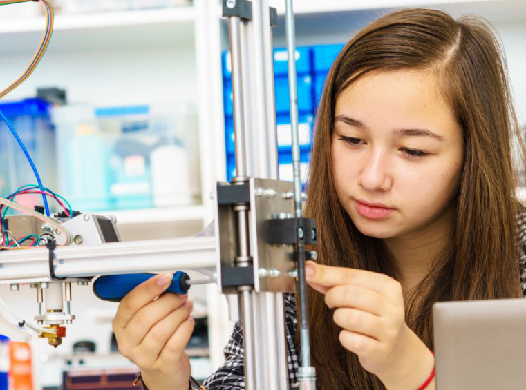 An engineer interacting with a 3D printer