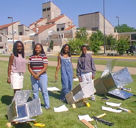 Four teens and three shiny, box-type solar ovens. Four teens and three shiny, box-type solar ovens.