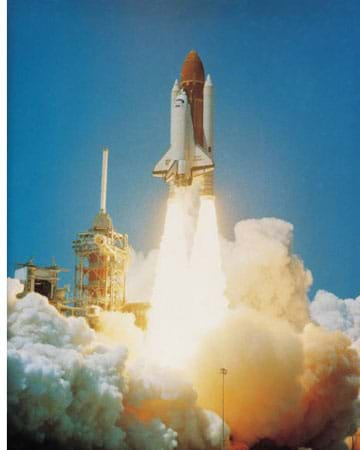 Photo shows a US space shuttle lifting off with much fire and smoke seen below the rocket.