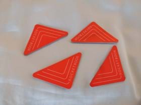 Four orange stickers that need a holding place, which is the inspiration for the design of a 3D printed desk organizer. 
