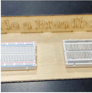 A photo of two breadboards showing metal connections in vertical columns and horizontal rows.