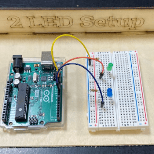 Photo of two LEDS (green and blue) that are wired in parallel with an Arduino using a breadboard. 