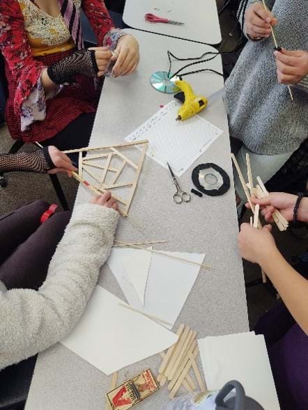 Four students working together on the mousetrap car design challenge.