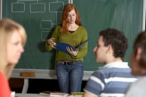 Photo shows a teenager giving a report in the front of the class.