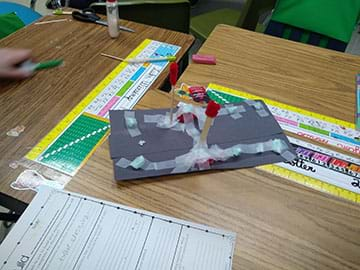 A student using tape to create stop signs.