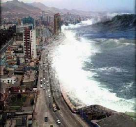 An aerial photograph shows a gigantic crashing wave just as it hits land in Japan, pouring onto a coastal highway with vehicles, buildings and skyscrapers nearby.