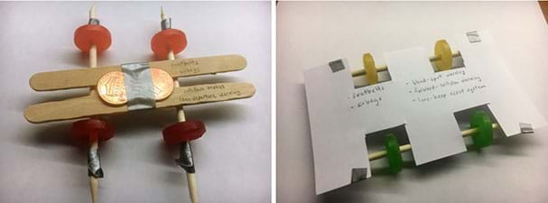 Two photos compare two possible mint-mobile designs. Left: A mint-mobile with four wheels, two wooden dowels, two popsicle sticks, and two pennies taped to the top; writing on the popsicle sticks indicates that this car has safety features of seatbelts, airbags, antilock brakes, and lane-departure warning. Right: A mint-mobile with four wheels, two wooden dowels, and an index card; writing on the index card indicates that this car has safety features of seatbelts, airbags, blind-spot and forward-collision warning, and lane-keep assist system.
