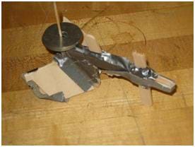 Photo shows a rudimentary model plow made from thin pieces of wood and duct tape.