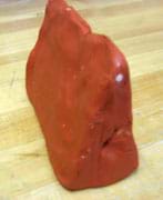 Photo shows a triangular wedge of red clay.