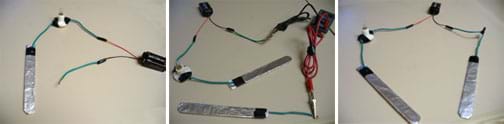 Three photos: (left) A long, flat aluminum foil-covered paddle wired to a miniature light bulb socket, further wired to the red wire on the battery cap of a 9-volt battery, with another wire from the black wire of the battery cap. (middle) From the first photo, a multimeter is added to the black wire of the battery cap, then it is connected via wire and alligator clip to the second electrode. (right) From the first photo, the black wire of the battery cap is connected to the second electrode.