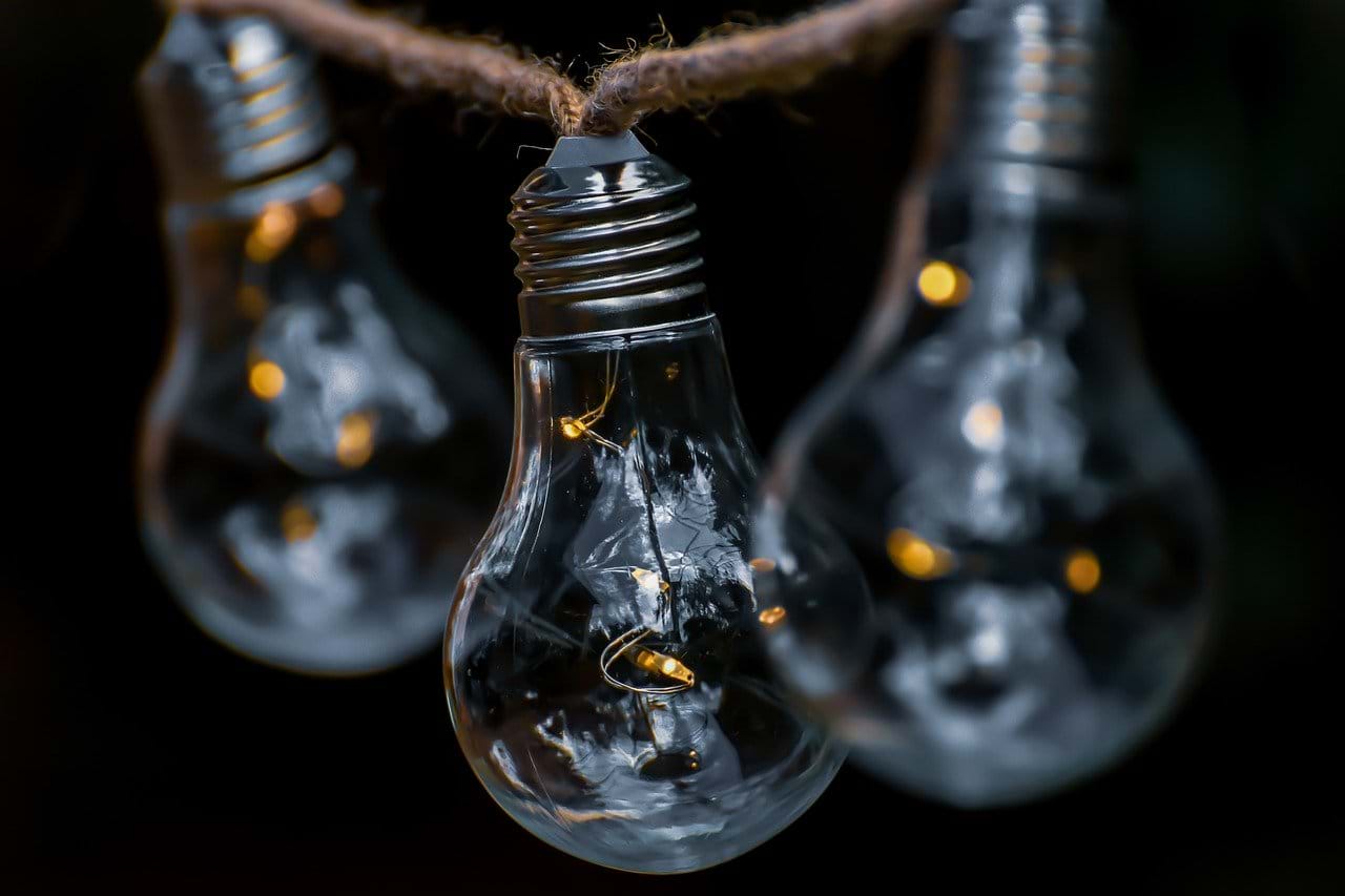Image of three illuminated light bulbs on a piece of string. 