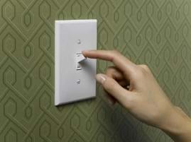 A finger pressing an on/off switch.