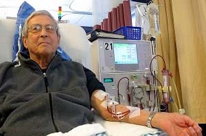 A photograph shows a man in a hospital bed connected to a dialysis machine receiving dialysis. 