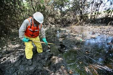 A contractor removing pools of oil that was released by a local refinery.