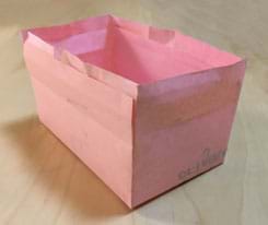 A photograph shows a rectangular box (5 x 3 x 3 inches) with four sides and a bottom, but no top, which is made from a cut and taped piece of pink paper.