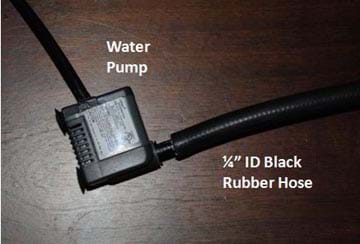 Photo shows hose connection set-up, which includes a small water pump connected to black ¼" rubber hosing.