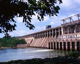 Photo shows a concrete dam blocking a river's passage.