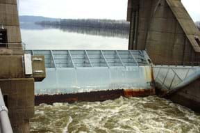 Photo shows a concrete and metal structure enclosing a section of a river.