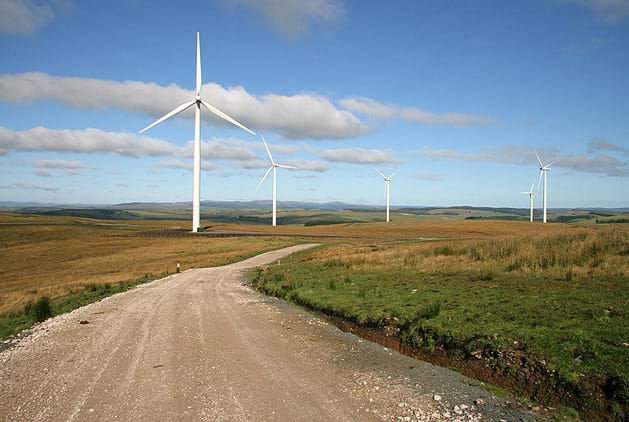A photograph of wind turbines, also known as a wind farm. Blowing wind causes a turbine to rotate, turning an electric motor which makes electricity.