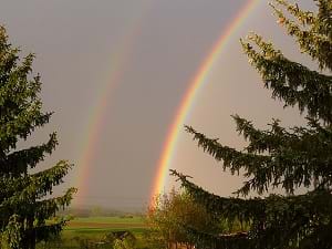 A photograph shows a double rainbow in the sky.