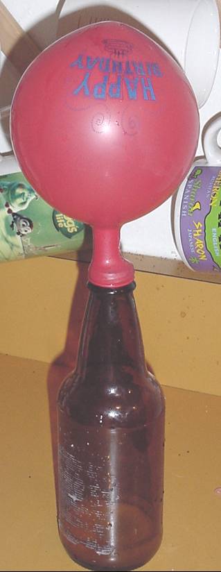 A photograph shows an inflated balloon on the top of a narrow-necked bottle.