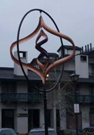 Photograph of curly steel pieces hanging inside of a steel circle.