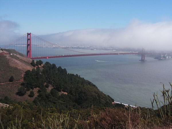 Red spires of the bridge in fog.