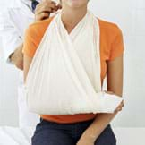 Photo shows a girl with a casted lower arm resting in a cloth sling from her neck.